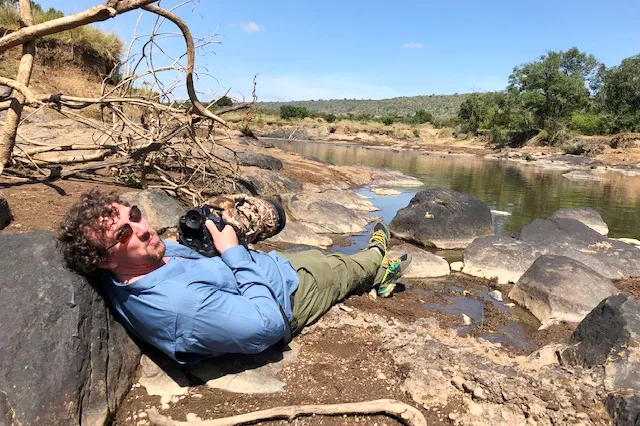Sean with camera next to watering hole in Kenya
